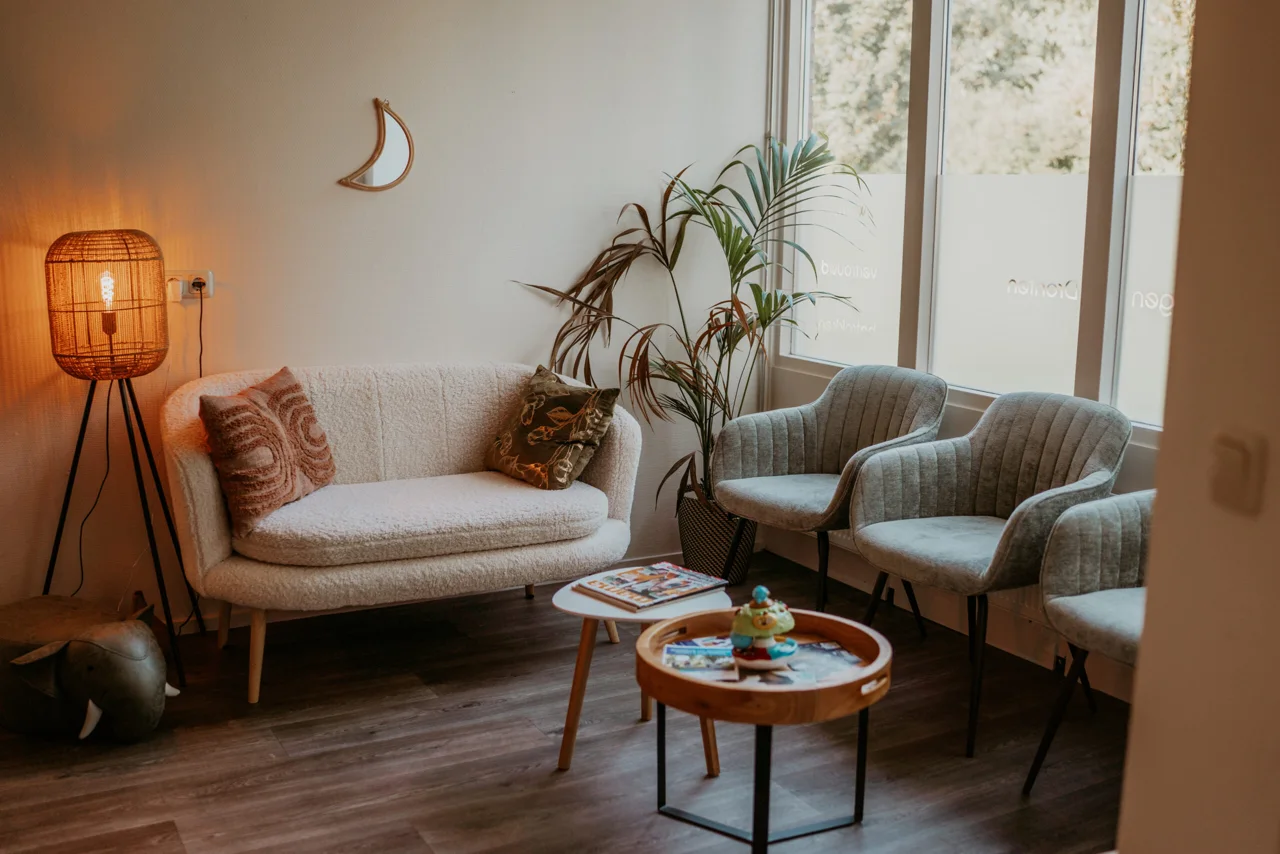 De wachtkamer van Verloskundigen Dronten met een bank en comfortabele stoelen